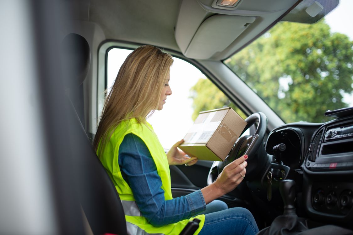 Courier holding a parcel inside a vehicle