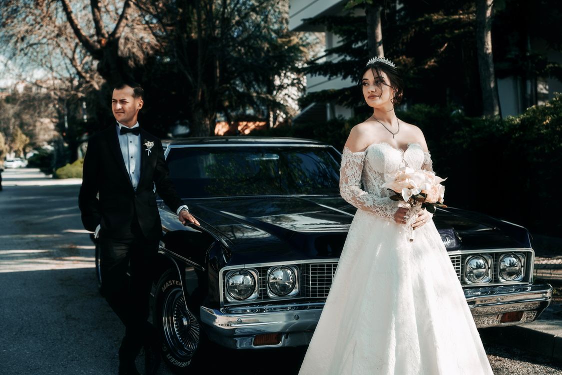 Wedding couple beside a classic car